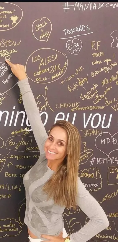 Clau apontando para seu nome escrito em um mural de recados.